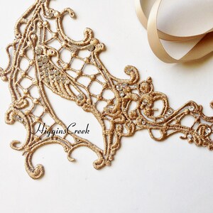 May include: Gold lace trim with a delicate floral design and clear rhinestones. The trim is perfect for adding a touch of elegance to any project.