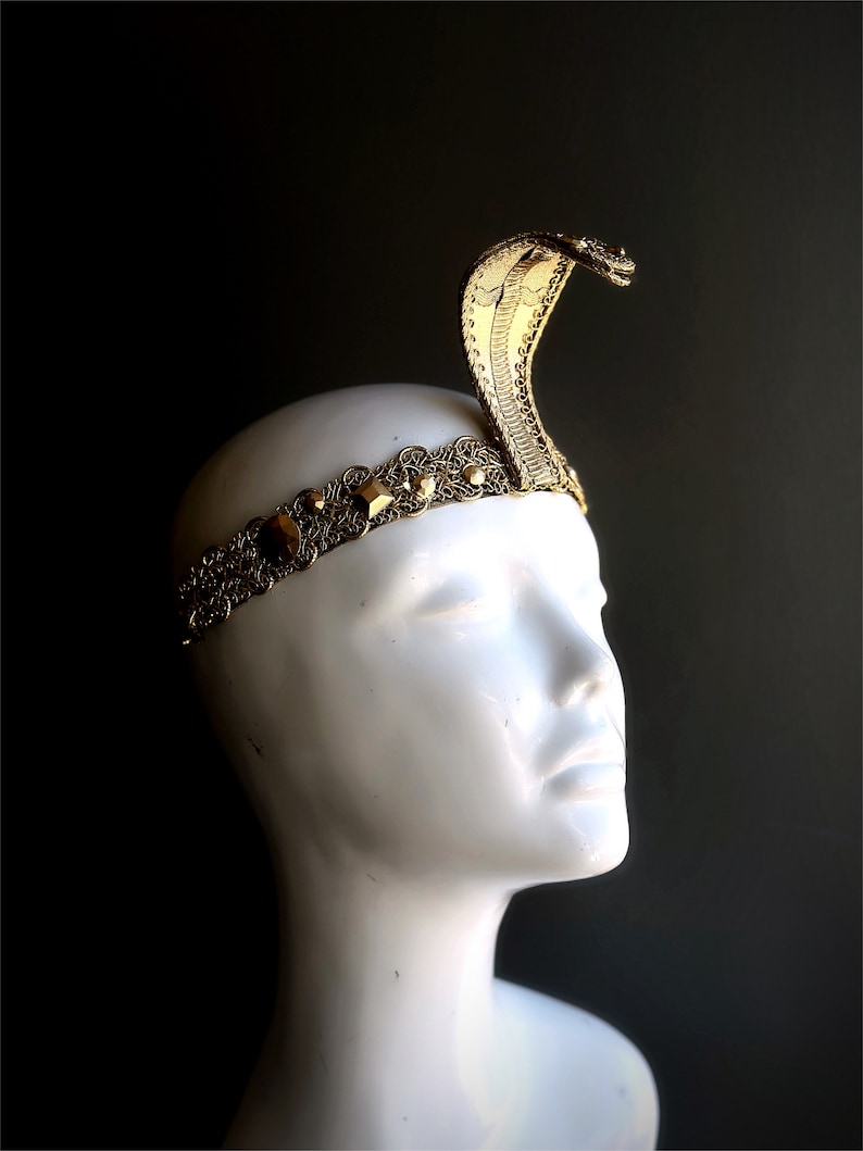 May include: A gold snake head headband with a gold chain and decorative stones