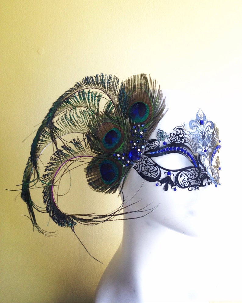 May include: A black masquerade mask with blue and silver accents and a peacock feather embellishment.