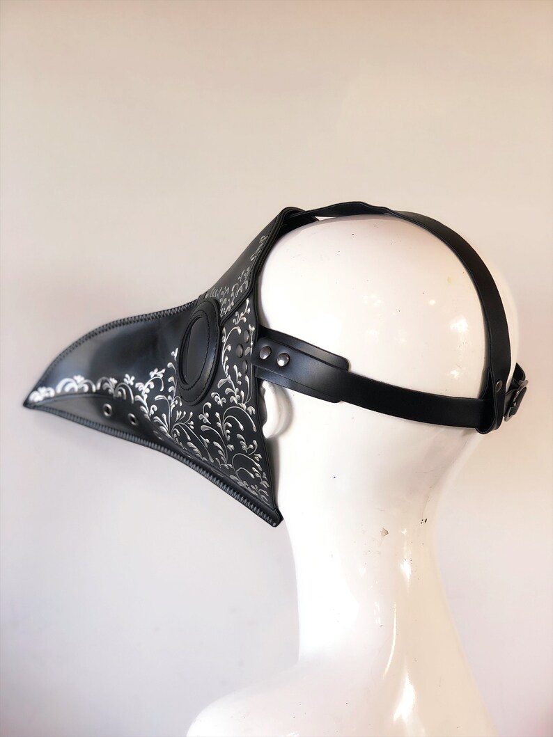 May include: Black leather plague doctor mask with silver floral detailing and adjustable straps.