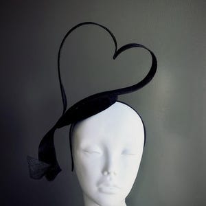 Könnte beinhalten: Ein schwarzes Samt-Haarband mit einem herzförmigen Design. Das Haarband wird auf einem weißen Mannequin-Kopf getragen.