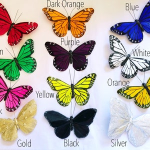 May include: Assortment of twelve decorative butterflies in various colors, including red, dark orange, blue, purple, green, white/black, orange, yellow, pink, gold, black, and silver.