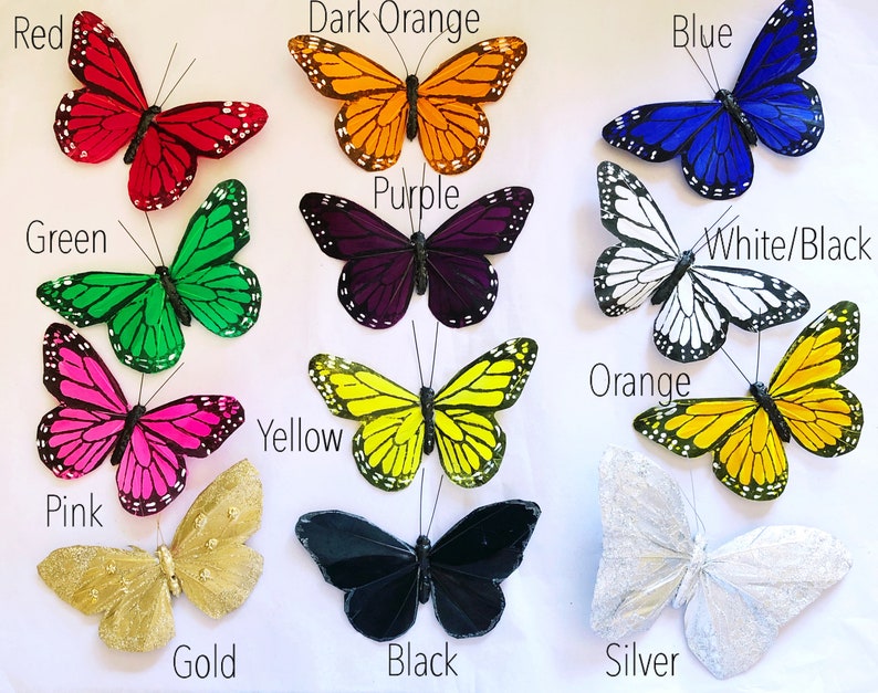 May include: Assortment of twelve decorative butterflies in various colors, including red, dark orange, blue, purple, green, white/black, orange, yellow, pink, gold, black, and silver.