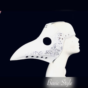 Pode incluir: Uma m&aacute;scara de m&eacute;dico da peste em couro branco com um bico longo e curvo e recortes florais decorativos. A m&aacute;scara tem orif&iacute;cios para os olhos e &eacute; rebitada. O texto "Basic Style" est&aacute; na parte inferior.
