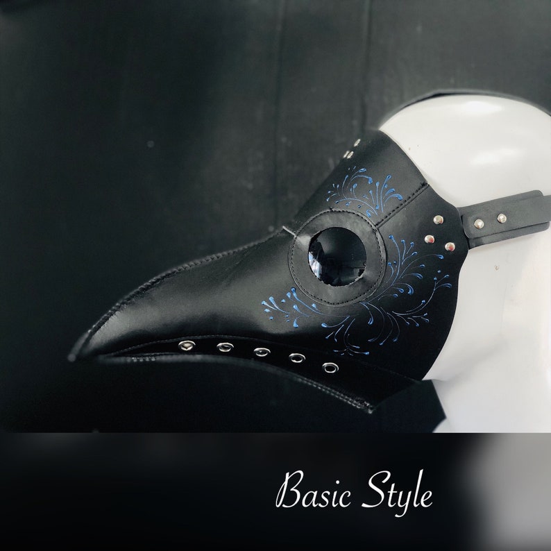 May include: Black leather plague doctor mask with a blue floral design and a round eye opening. The mask has a strap and is decorated with silver studs.