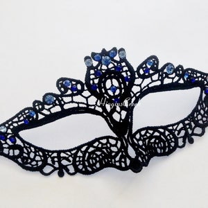 May include: Black lace masquerade mask with blue rhinestones. The mask has a delicate design and is perfect for a costume party or a night out.