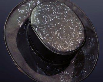 Puede incluir: Un sombrero fedora de cuero negro con un diseño floral plateado.