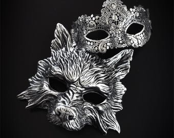 Puede incluir: Dos máscaras de carnaval, una de diseño de lobo plateado y la otra de encaje plateado y negro.