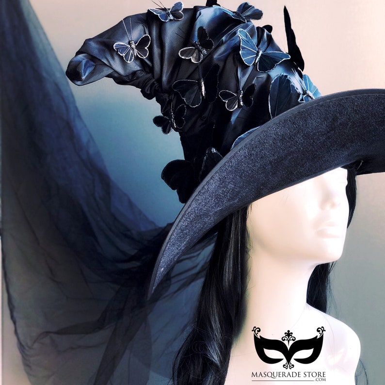May include: A black witch hat with a wide brim and a tall, pointed crown. The hat is decorated with black velvet and numerous black butterfly embellishments. The hat is worn by a person with long black hair.