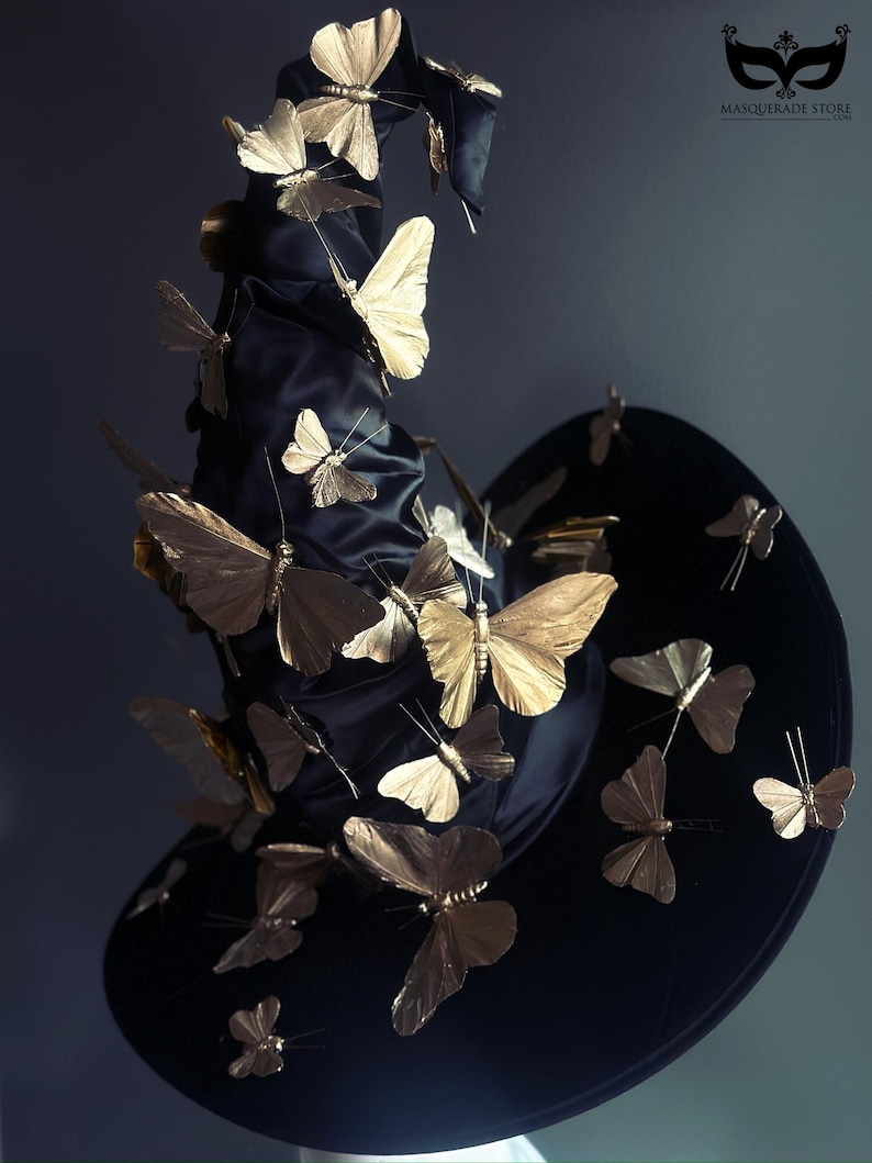 May include: A black witch hat adorned with numerous gold-colored butterfly embellishments. The butterflies are of varying sizes and appear to be attached to the hat, creating a whimsical and elegant design. The hat has a wide brim and a tall, pointed crown.