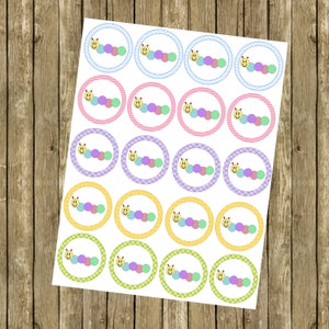 May include: A sheet of 20 round cupcake toppers featuring a smiling caterpillar with a yellow face and multi-colored body. The toppers are printed on white paper with a variety of colorful borders.