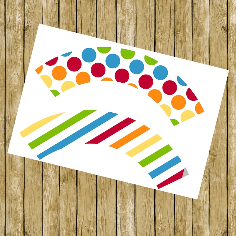 May include: Printable cupcake wrappers with a colorful polka dot and striped design. The wrappers are in the shape of a half-circle.