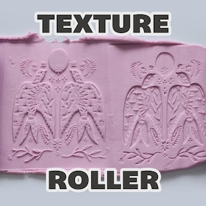 May include: A purple cylindrical texture roller with a relief pattern of two birds, celestial suns, moons, and stars. The roller is shown pressing into a flat sheet of light purple clay, leaving a clear, repeating impression of the intricate design.