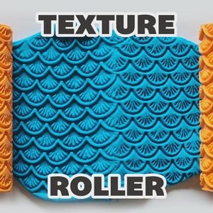 May include: Two orange cylindrical texture rollers with a raised scalloped shell pattern flanking a central piece of bright blue clay that has been imprinted with the same repeating shell design. The text TEXTURE ROLLER is visible.