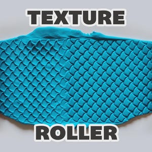 May include: Two orange cylindrical texture rollers with a repeating scale pattern positioned on either side of a flat, bright blue piece of clay that has been imprinted with the same scale design. The text TEXTURE ROLLER is visible.