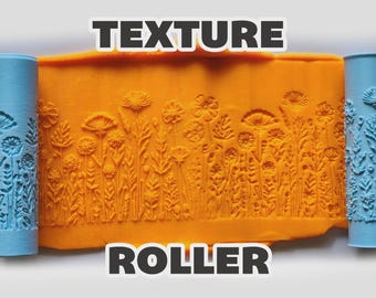 May include: Two light blue cylindrical texture rollers flanking a central orange slab of clay. The clay features an embossed pattern of various wildflowers and grasses. The text "TEXTURE ROLLER" is displayed in bold white letters at the top and bottom.