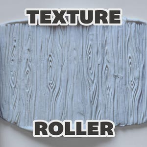 May include: Two purple cylindrical texture rollers with a wood grain pattern positioned on either side of a white clay slab that has been imprinted with the same wood grain texture. The text "TEXTURE ROLLER" is displayed in bold white letters.