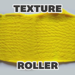 May include: A blue cylindrical texture roller with a raised scale pattern, shown pressing into a flat sheet of bright yellow clay. The roller features a repeating reptilian skin design that leaves a clear impression on the surface of the yellow material.
