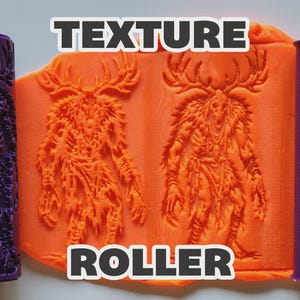 May include: Two purple cylindrical texture rollers featuring a detailed embossed design of a horned creature with a skull head. Between the rollers is a flat sheet of orange modeling clay displaying the same creature pattern pressed into its surface.