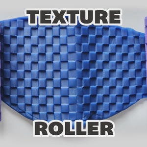 May include: Two light purple cylindrical texture rollers with a raised square grid pattern positioned on either side of a flat, blue, pliable material that has been embossed with the same square grid texture. The text TEXTURE ROLLER is visible.