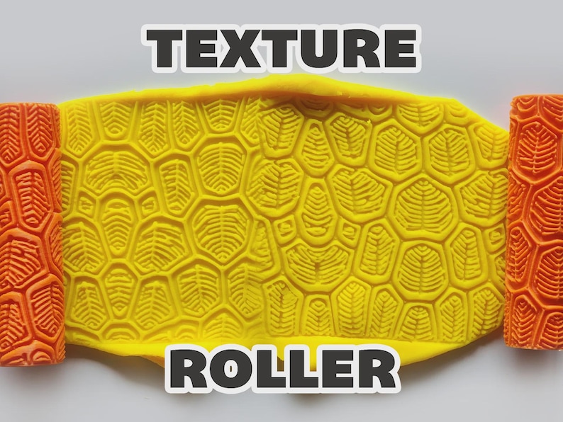 May include: Two orange cylindrical texture rollers with a repeating geometric leaf-like pattern flanking a central yellow slab of clay. The clay displays a deep, embossed impression of the same pattern. The text "TEXTURE ROLLER" is visible.