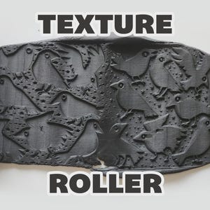 May include: A bright yellow cylindrical texture roller with a repeating bird and star pattern, shown pressing into a flat piece of dark gray clay to reveal an embossed design. The text "TEXTURE ROLLER" is displayed in bold white letters.