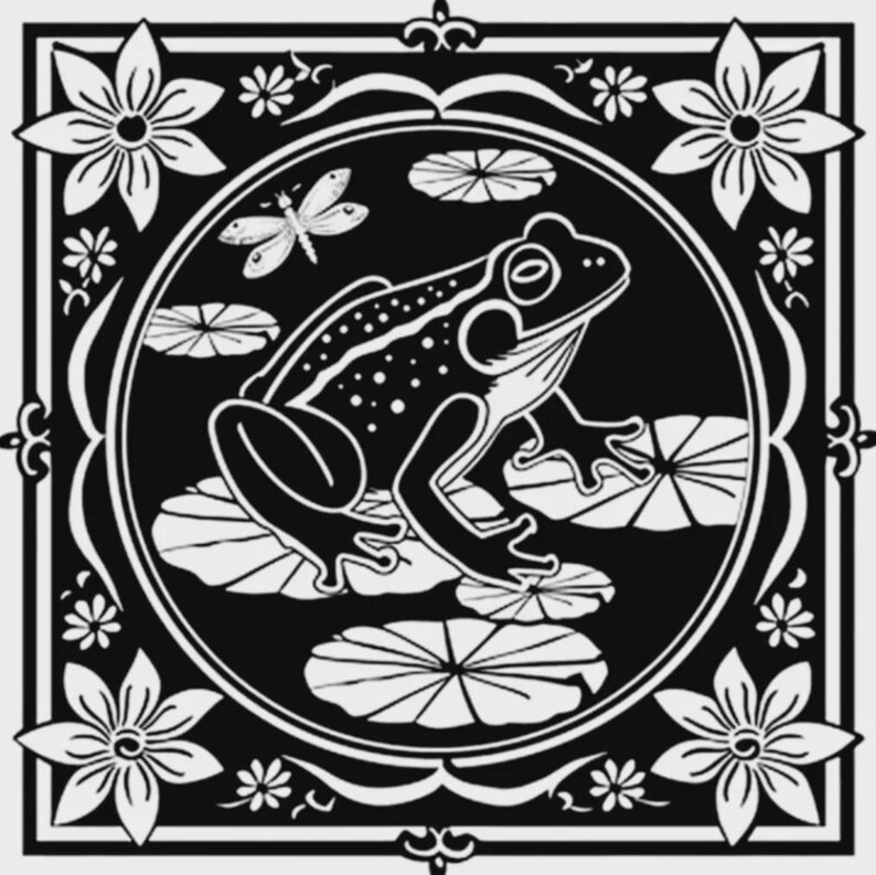 Op de afbeelding: Een vierkante zwart-wit grafische print met een centrale cirkelvormige omlijsting met een kikker op waterlelies en een libel erboven. De hoeken van de vierkante rand zijn versierd met gestileerde bloemmotieven en kleine bloemetjes.