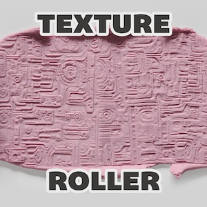 May include: A dark pink cylindrical texture roller with an intricate circuit board pattern, shown pressing into a light pink clay surface. The text "TEXTURE ROLLER" is displayed in bold white letters at the top and bottom of the image.