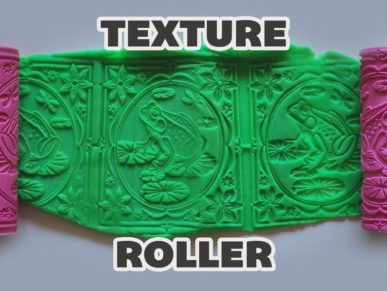 Op de afbeelding: Een roze cilindrische textuurroller met een herhalend patroon van kikkers op waterlelies, libellen en bloemen, die het ontwerp in een platte plaat van felgroene klei drukt. De tekst "TEXTURE ROLLER" is in het wit met een zwarte rand gedrukt.