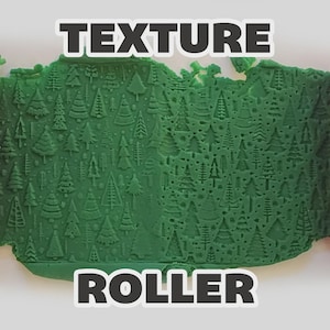 May include: A pink cylindrical texture roller with an engraved pattern of various evergreen trees, shown pressing into a flat sheet of green clay to create a repeating forest design. The text "TEXTURE ROLLER" is displayed in bold white letters.