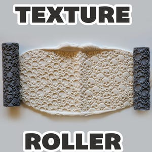 May include: A texture roller with a skull pattern, alongside a clay sheet with the same skull design. The words "TEXTURE" and "ROLLER" are displayed in bold, black text. The rollers are dark gray.