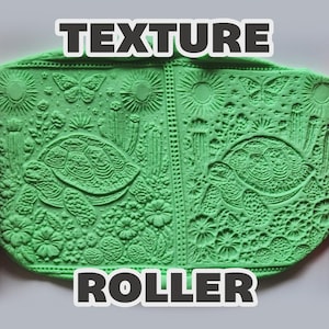 May include: Two red cylindrical texture rollers flanking a central piece of light green clay. The clay features a relief pattern of turtles, butterflies, suns, cacti, and flowers. The text "TEXTURE ROLLER" is displayed in bold white letters.