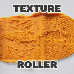 May include: Two light blue cylindrical texture rollers positioned on the left and right sides of a flat, orange, pliable material. The material features a repeating embossed pattern of fish swimming among aquatic plants, labeled TEXTURE ROLLER.