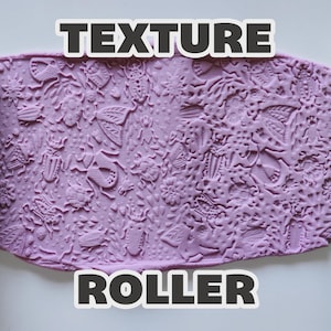 May include: A light green texture roller with an embossed insect and floral pattern, shown alongside a lavender-colored clay sheet imprinted with the same design. The text "TEXTURE ROLLER" is displayed in bold white letters with a black outline.