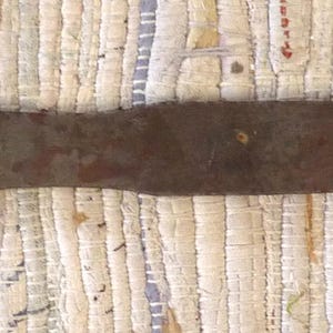 May include: An antique metal tool with a wooden handle. The metal blade is long and tapered, showing signs of age and wear. The wooden handle is a warm brown color, and the tool appears to be a vintage craft or woodworking instrument.