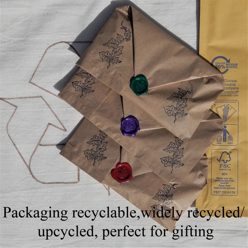 3 packed up for dispatch in brown kraft paper with wax seals.  The back of a postal envelope showing eco credentials, all on a recycle logo stating:  Packaging recycleable, widely recycled/ upcycled, perfect for gifting