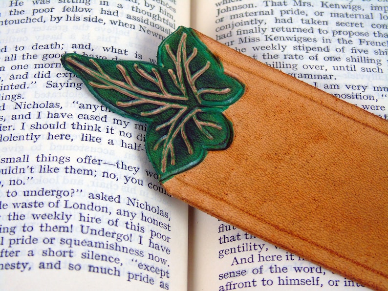 Detail of the green, cut out leaf leather bookmark on an open book