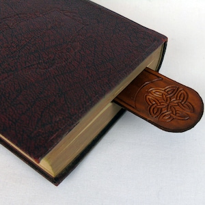 Domed top, celtic knot leather bookmark in a navy, bound book