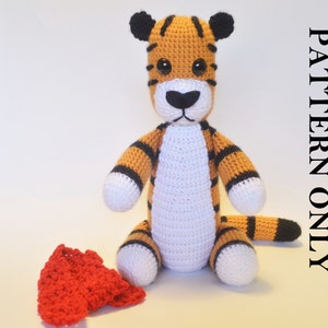 May include: A crocheted tiger stuffed animal with orange and black stripes, white fur on the belly, and black eyes. The tiger is sitting on a white surface.