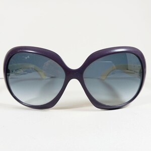 Peut inclure: Lunettes de soleil violettes surdimensionn&eacute;es avec verres d&eacute;grad&eacute;s. Les montures sont violet fonc&eacute;, et les verres passent d'une teinte plus fonc&eacute;e en haut &agrave; une teinte plus claire en bas. Les branches sont jaune clair.