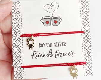 May include: Two red string bracelets with gold charms of stick figures. The card reads "Boys Whatever Friends Forever" with a drawing of two coffee cups with hearts.