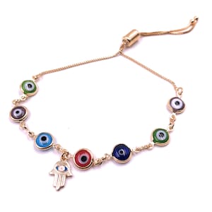 May include: Gold adjustable bracelet with a hamsa hand charm and six evil eye charms in different colors, including blue, green, red, and purple.