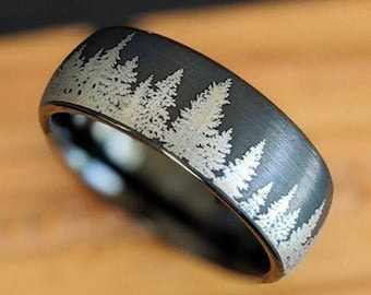 May include: A black tungsten carbide ring with a brushed finish and a silver-colored forest silhouette design.