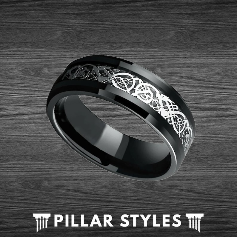 May include: A black and silver wedding band with a Celtic knot design. The band is made of tungsten carbide and has a polished finish.
