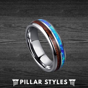 May include: A silver tungsten carbide ring with a blue and brown inlay. The inlay is made of wood and opal.