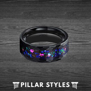 May include: Black tungsten carbide ring with a hammered finish and a blue, pink, and green opal inlay.  The ring is a popular choice for men's wedding bands.