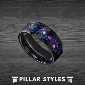 May include: Black tungsten carbide ring with a hammered finish and blue, green, and pink opal inlay.