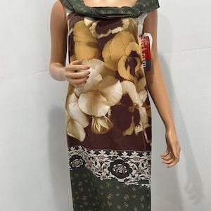 May include: A sleeveless knee-length dress featuring a large floral print in shades of brown, cream, and tan. The neckline has a dark green folded collar with a small floral pattern. A tag labeled The Back Room is attached to the side.