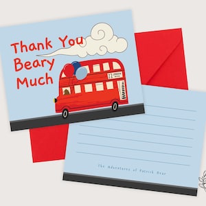 Puede incluir: Un juego de tarjetas de felicitación con una ilustración de un autobús rojo de Londres y el texto "Thank You Beary Much". Las tarjetas tienen un fondo azul claro y un sobre rojo. La tarjeta inferior tiene líneas para escribir.
