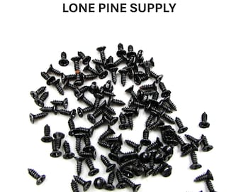May include: A pile of black screws with flat heads on a white background. The text "LONE PINE SUPPLY" is above the screws.